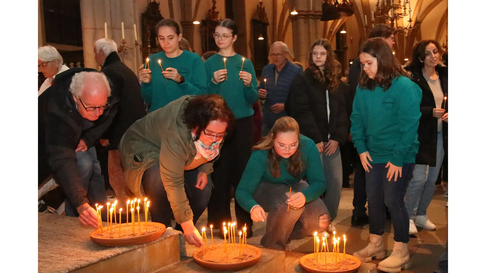 Die Teilnehmer der Interreligiösen Begegnung stellen Friedens- und Hoffnungslichter auf. (Foto: bb)