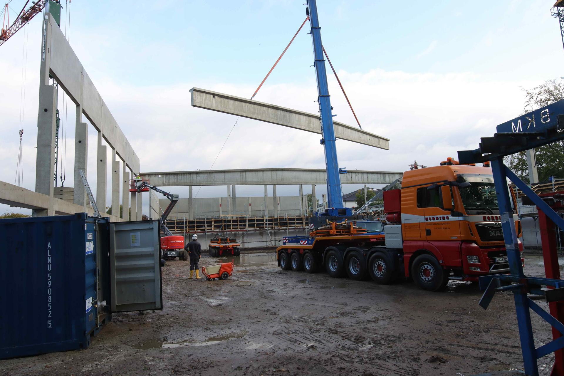 Auf der Baustelle: Mit Hilfe eines Spezialkrans werden die Dachträger angehoben und in Position gebracht. (Foto: tau)