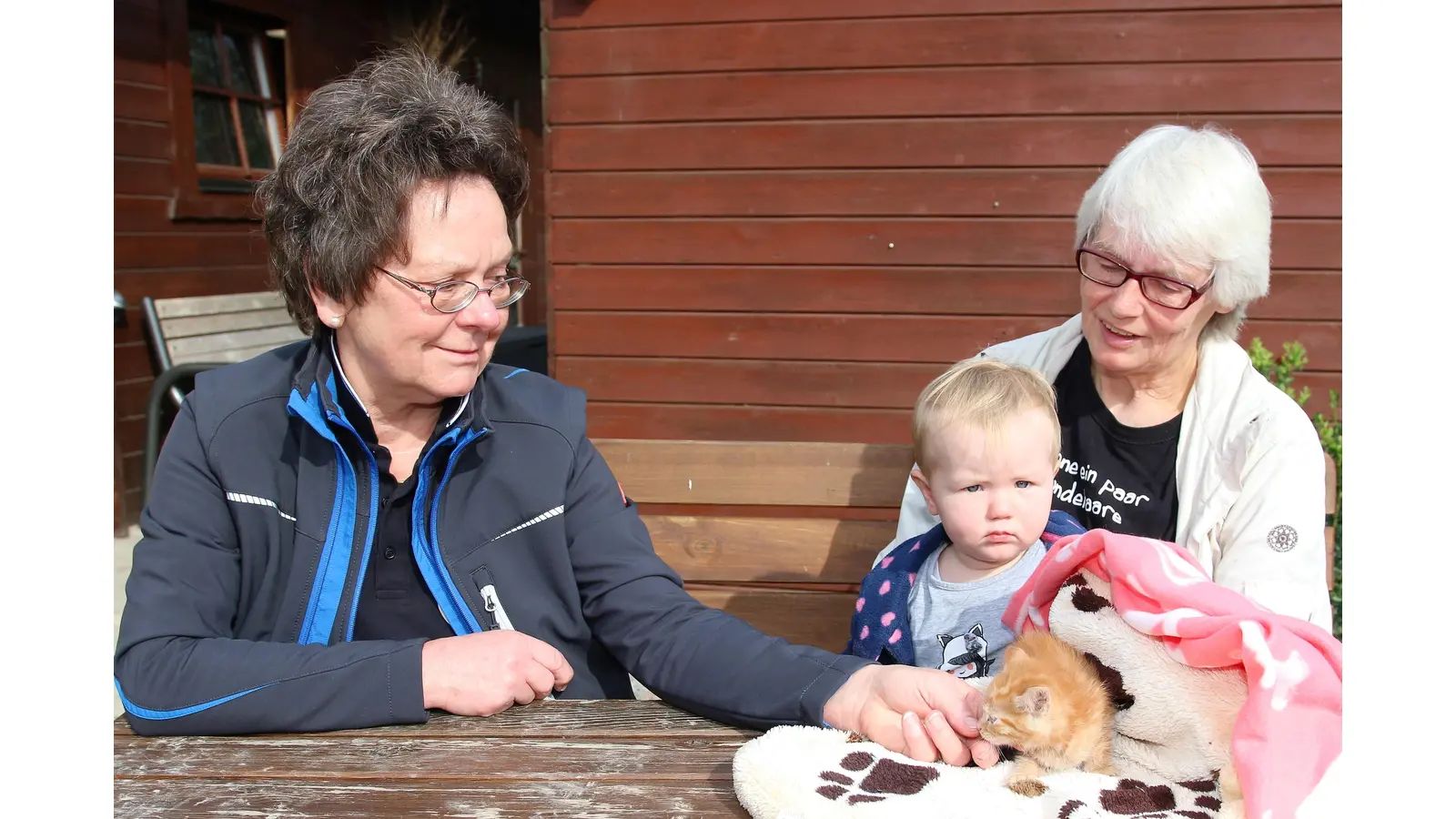 Jutta Schneider (li.), Vorsitzende des Tierschutzvereins Nenndorf-Rodenberg, nimmt die Spende vom Tiersegnungsgottesdienst von Brigitte Wilczok und Enkelin Johanna entgegen. Alle drei hoffen, dass die kleine Fundkatze einen neuen Halter findet.<br> (Foto: Borchers, Bastian)