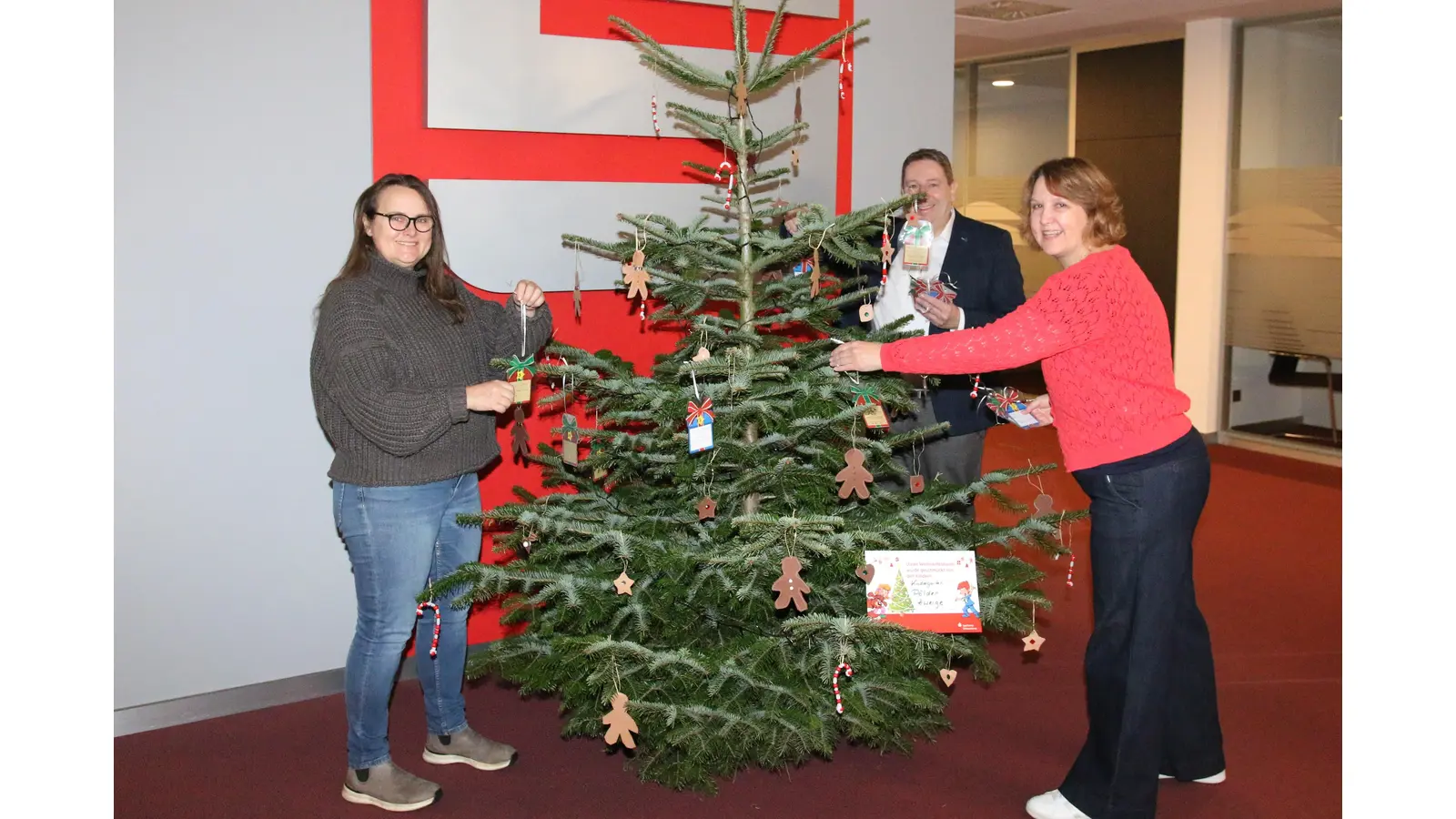 Nicole Wehner, Michaela Becker und Frank Frevert hängen die Wunschanhänger an den Baum. <br><br> (Foto: bb)