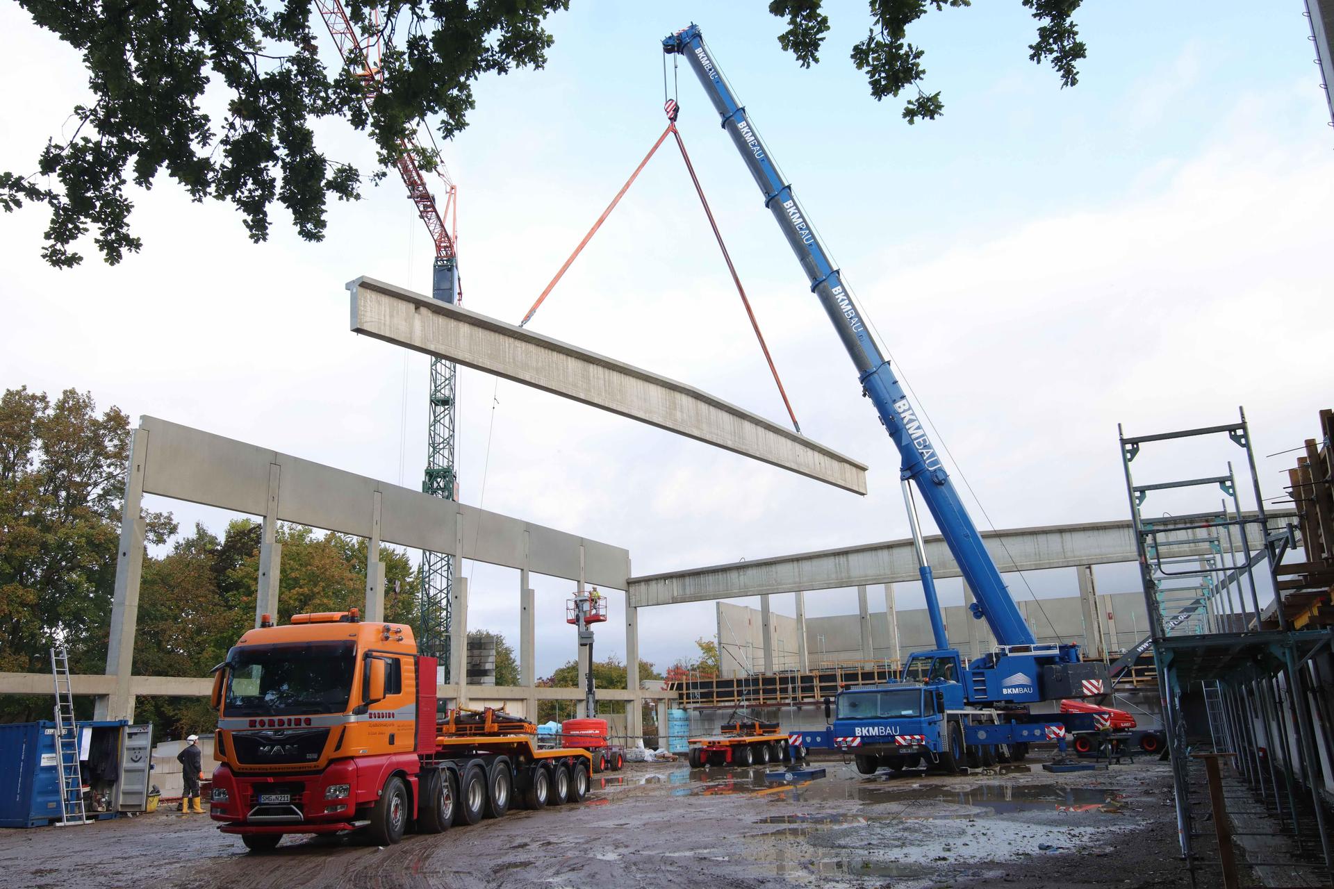 Auf der Baustelle: Mit Hilfe eines Spezialkrans werden die Dachträger angehoben und in Position gebracht. (Foto: tau)