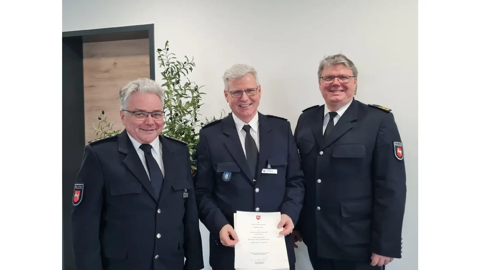 Stefan Schara, Leiter der Polizeiinspektion Nienburg/Schaumburg (li,) und Mathias Schröder, Polizeivizepräsident der Polizeidirektion Göttingen (re.) verabschieden Kommissariats-Leiter Michael Panitz in den Ruhestand. (Foto: polizei)