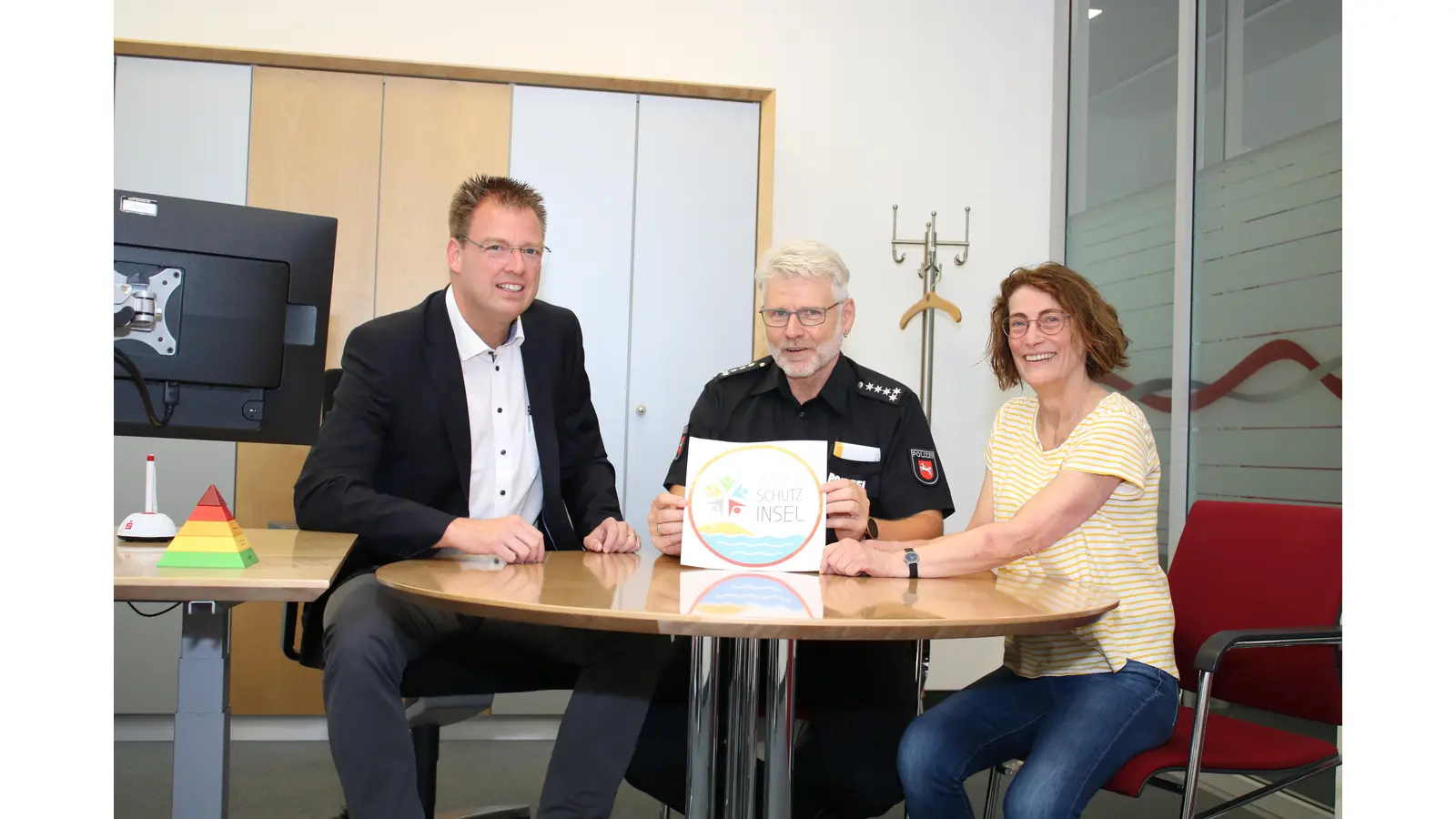 Gerd Krome (Sparkasse), Michael Panitz (Polizei) und Anja Adelt (Stadtmarketing) zeigen die Vorteile des Projekts Kinderschutz-Insel auf.  (Foto: cm)
