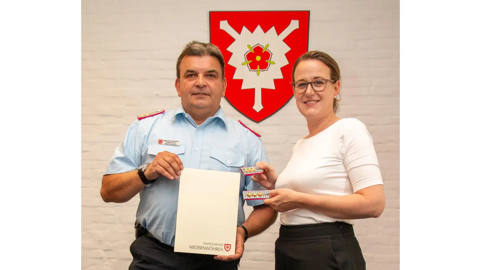 Samtgemeindebürgermeisterin Aileen Borschke (li.) übergibt Gregor Zimmermann Urkunde und neue Schulterstücke. (Foto: Privat)