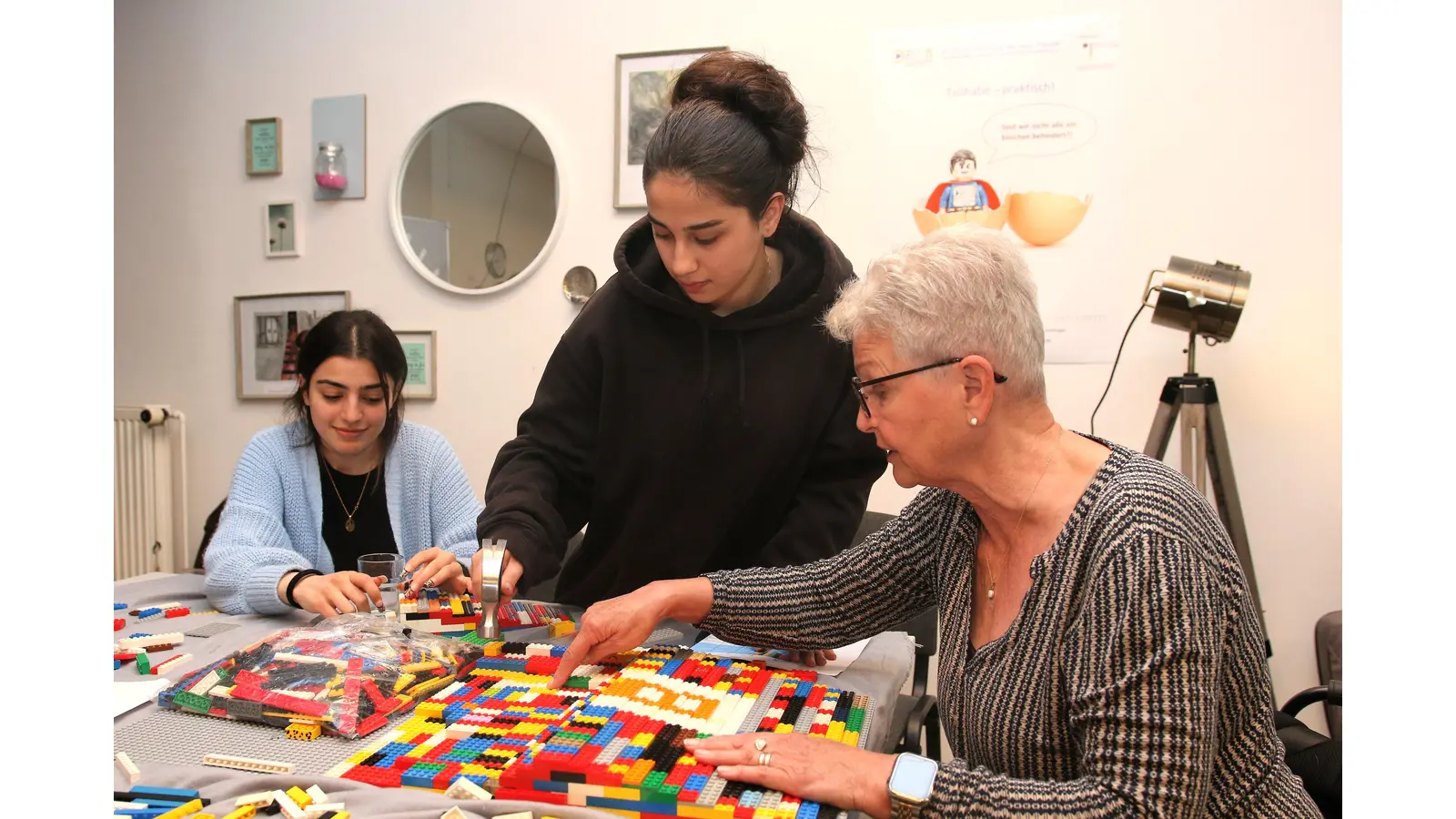 Shela Kudeda und Elin Azin von der Schule am Schlosspark setzen zusammen mit „Lego-Oma” Rita Ebel einen Teil der Rampe zusammen. (Foto: Borchers, Bastian)