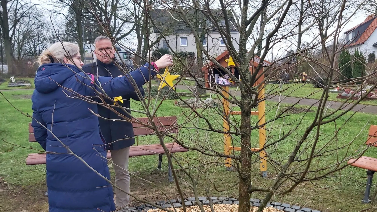 Die ersten Erinnerungssterne werden von Pastorin Anja Sievers und Samtgemeindedirektor Mike Schmidt an den den Taschentuchbaum gehängt. (Foto: gk)