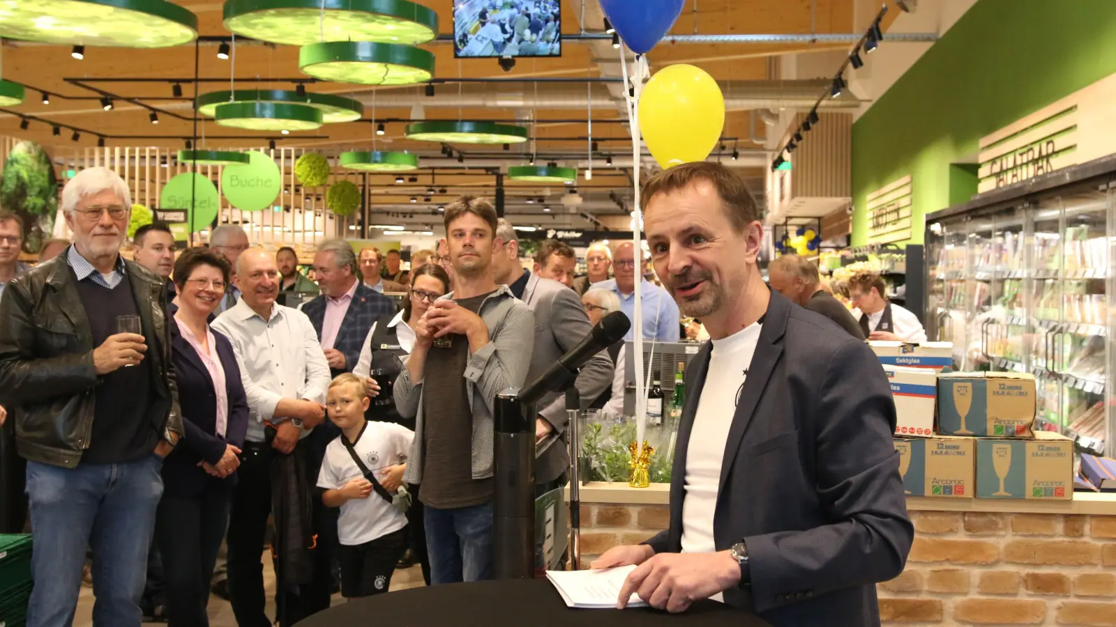 Ulf-U. Plath vom Edeka-Vorstandsteam gratuliert der Familie Kreisel zur Neueröffnung des Marktes in Lauenau. (Foto: bb)