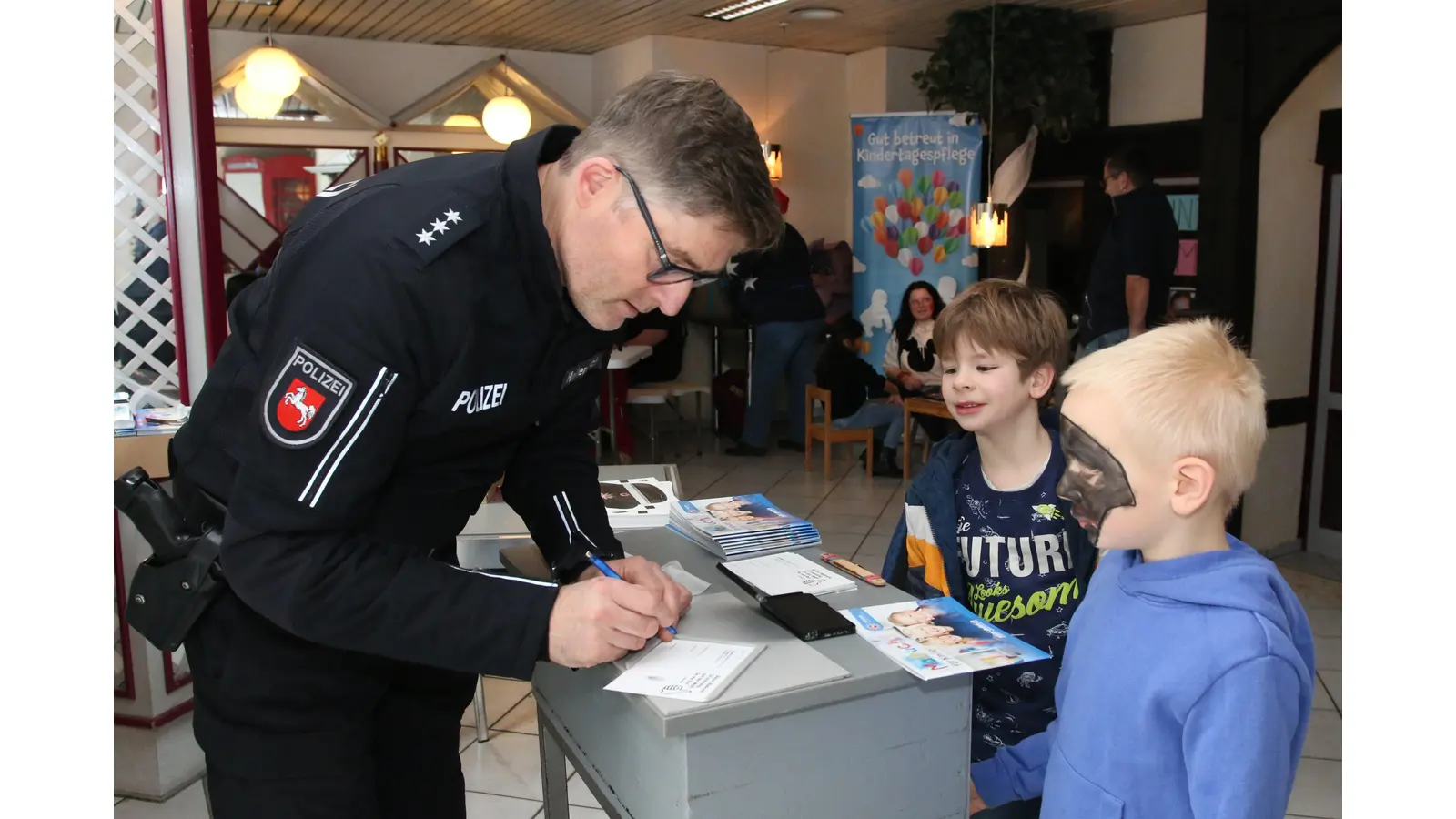 Kontaktbeamter Thomas Heidenreich füllt beim Adventsprogramm in der Marktpassage Karten für die Kinder aus.  (Foto: bb)